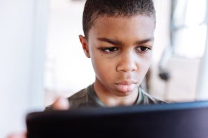 Boy using tablet with a serious face