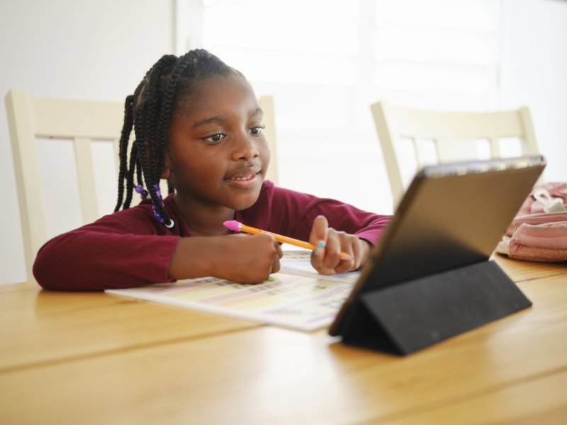 An elementary aged school student taking a test